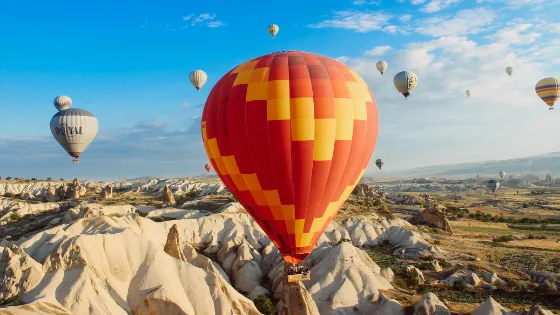 Globos aerostáticos de colores volando sobre las chimeneas de hadas en Capadocia, Turquía. Una actividad esencial para el turismo de aventura y las vacaciones en la región