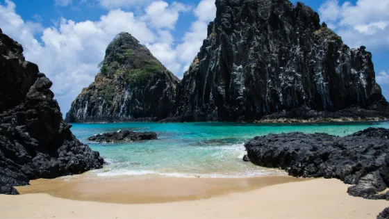 Praia do Cachorro en Fernando de Noronha, Brasil, con aguas turquesas y formaciones rocosas. Viajes a Brasil, playas exóticas y turismo de naturalez